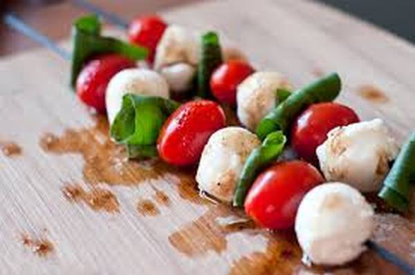 Fresh mozzarella balls, grape tomatoes and fresh basil served on a bamboo skewer and drizzled with a balsamic reduction.