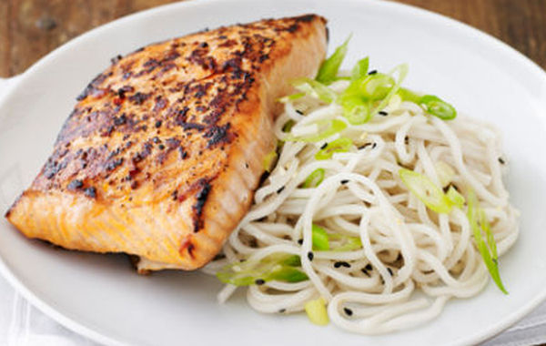 Pan seared crispy salmon drizzled with teriyaki sauce and served with sesame soy lo mein noodles and vegetables